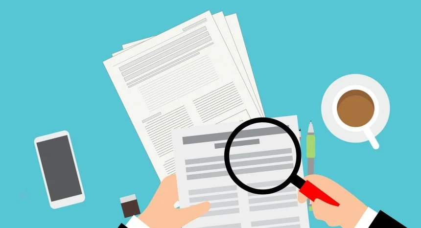 Flat illustration of two hands holding printed forms at a desk, one hand pressing a magnifying glass with a black rim and a red handle over a form, on a teal background with a smartphone, a cup of coffee and a pen.