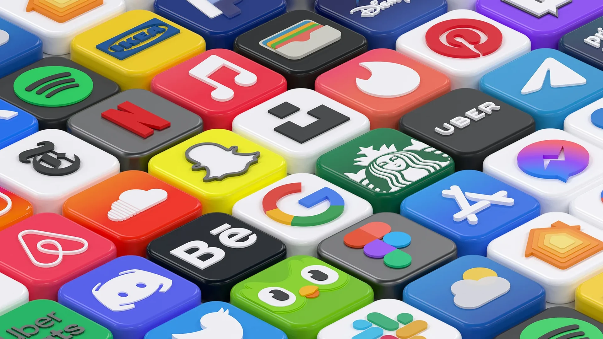 A tilted grid of glossy, square three dimensional app icons in many colors, among them a music note, a red letter N, a ghost outline, a multicolored G and an owl.
