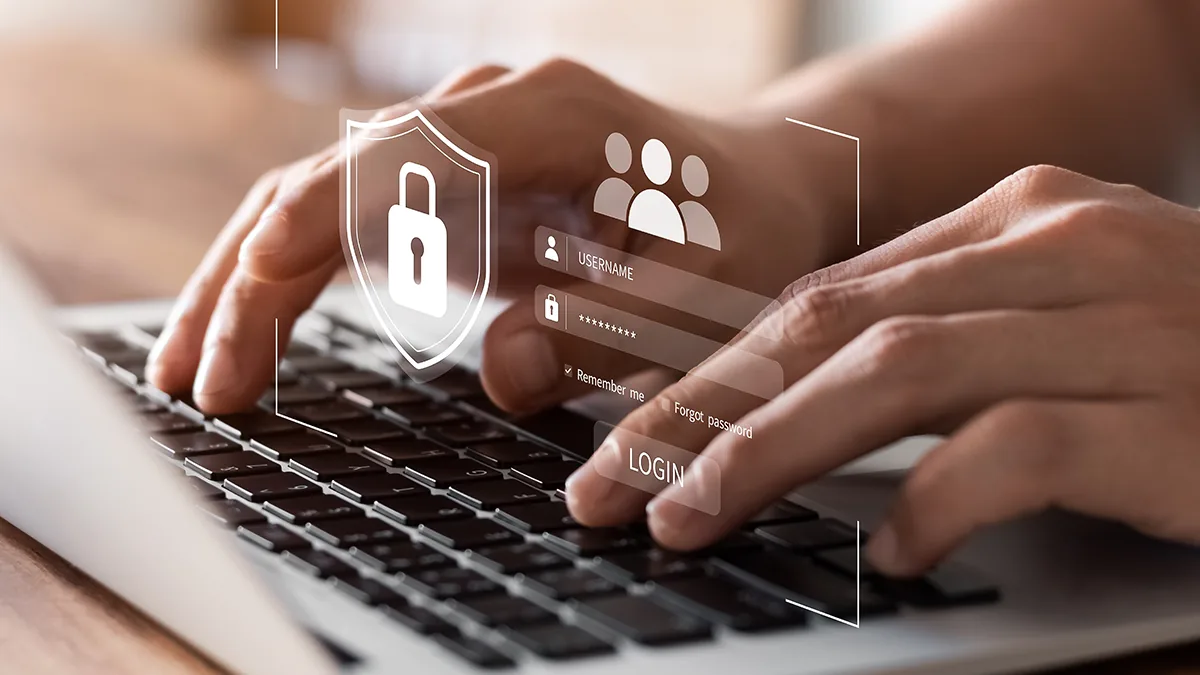Hands typing on a laptop keyboard beneath a graphic overlay of a padlock, a user icon and a login form.