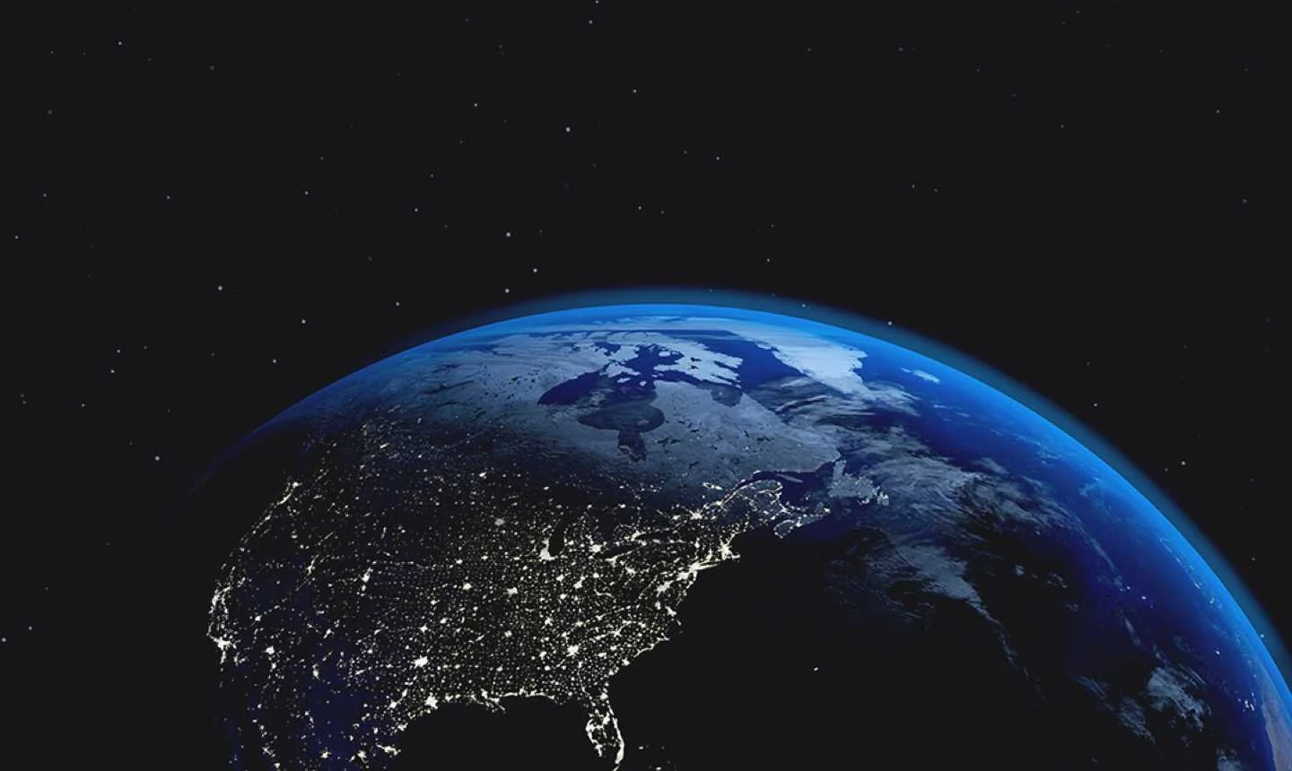 Earth seen from space against a black sky with small stars, a glowing blue edge along its curve, pale white and gray patches across the upper part, and clusters of white city lights across North America in the lower left.