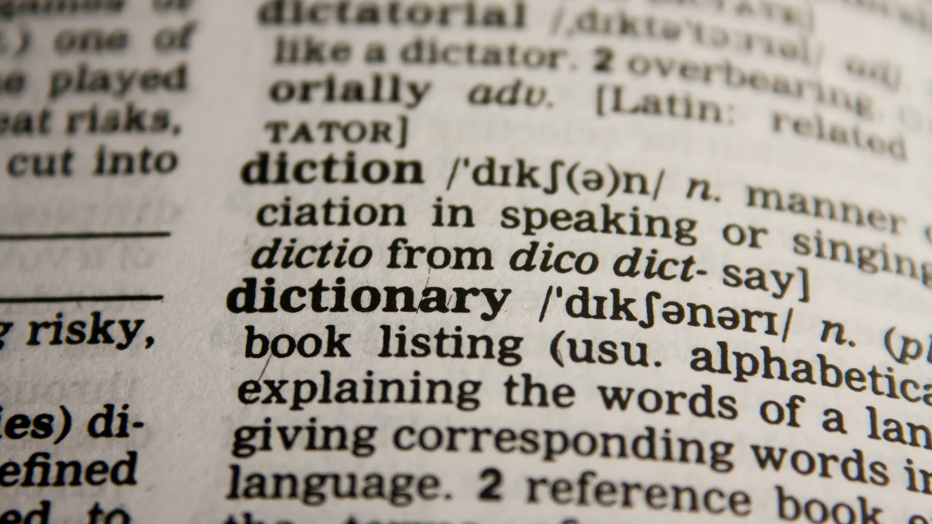 A close-up of a dictionary page with the entry for the word dictionary in focus.